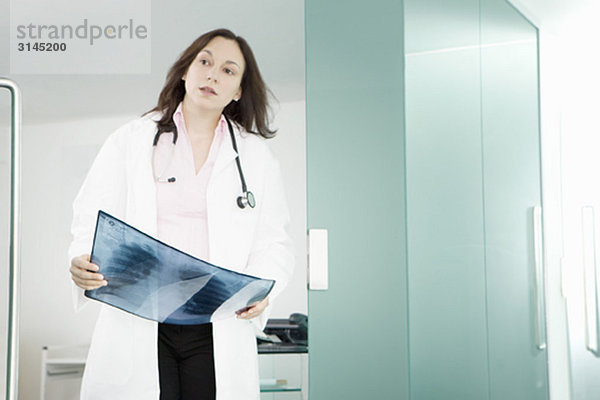 Eine Ärztin  die ein Röntgenbild hält.