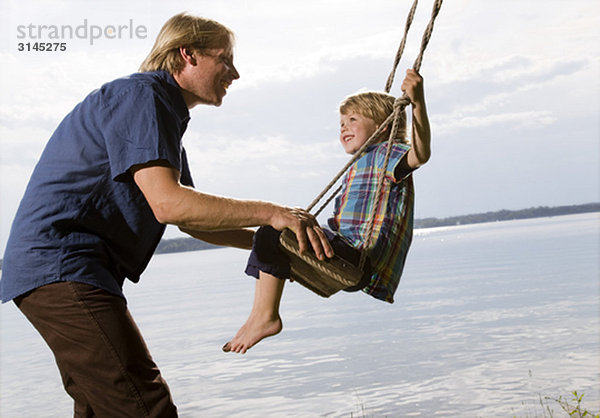 Vater mit Sohn auf Schaukel