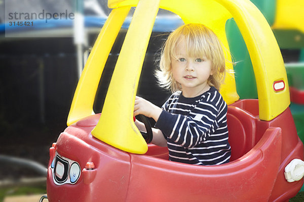 Junge in einem Spielzeugauto