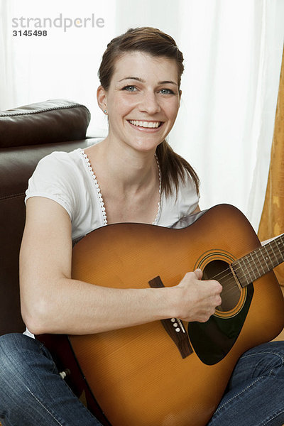 Junge Frau beim Gitarrespielen