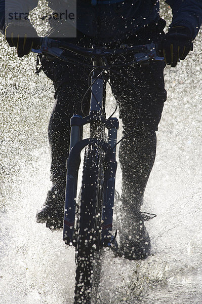 Mountainbike fahren durchs Wasser.