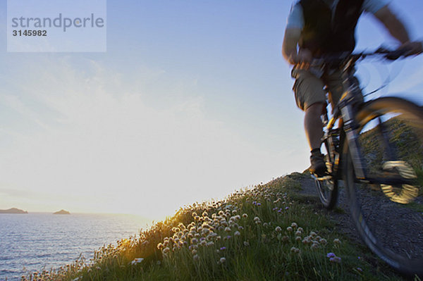 Mountainbiker auf einem Küstenweg.