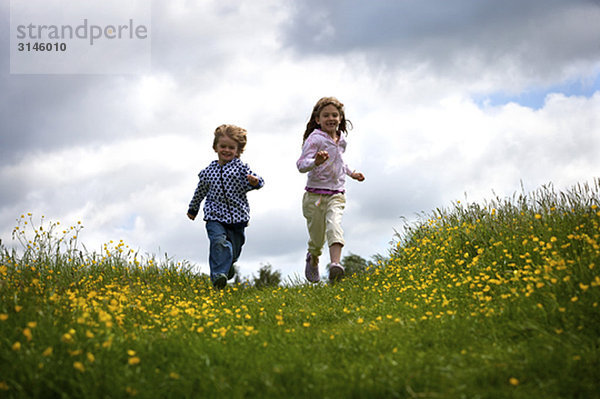 2 kleine Kinder laufen.