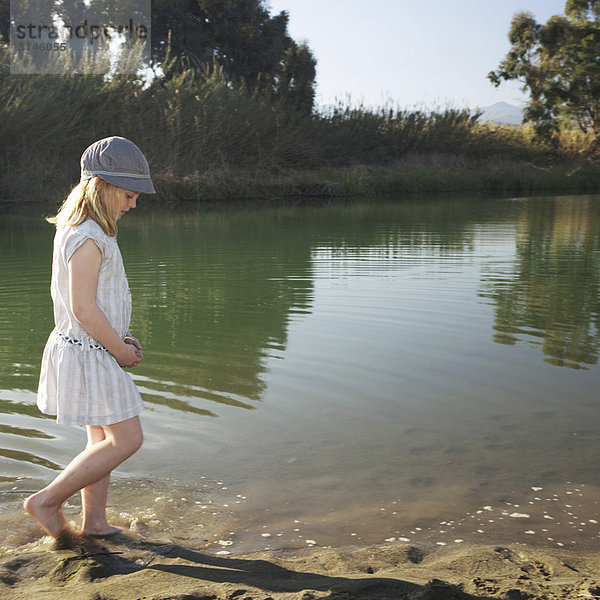 Junges Mädchen am Fluss mit Füßen im Wasser