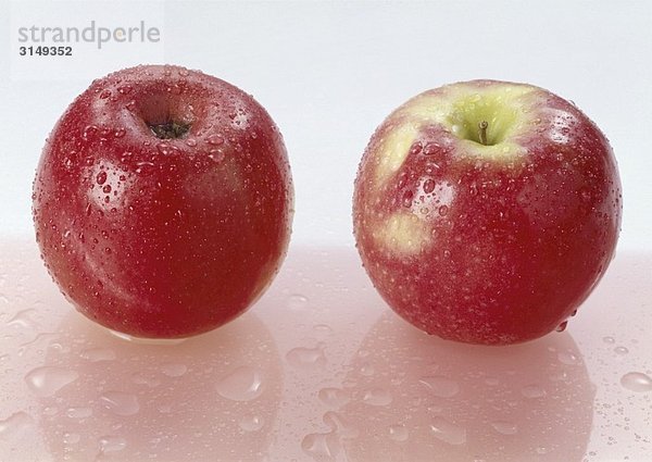 Zwei rote Äpfel mit Wassertropfen