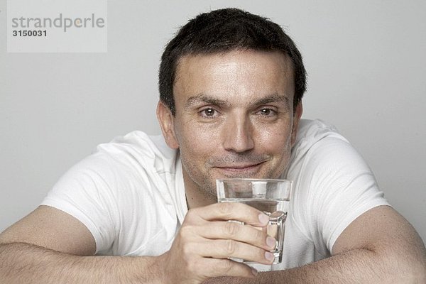 Mann hält Glas Wasser