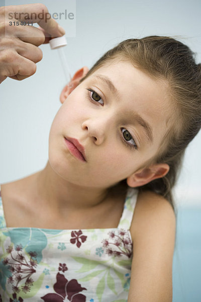 Arzt setzt Tropfen in das Ohr des kleinen Mädchens  abgeschnitten