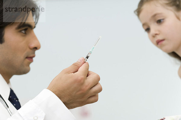 Kinderarzt zeigt kleine Mädchenspritze