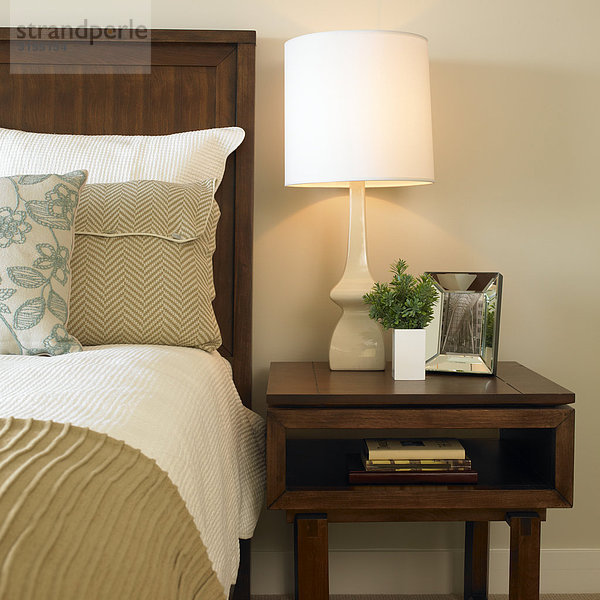 Bed and bedside Table with books  mirror and lamp  Victoria  British Columbia