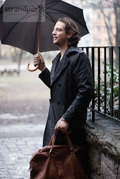 Ein Mann  der einen Regenschirm Schweden hält.