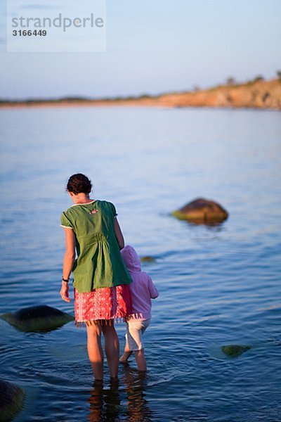 Mutter und Tochter stehen im Wasser Schweden.
