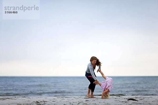 Zwei Mädchen am Strand am Meer Schweden spielen.