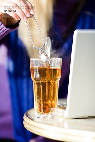 Junge Frau sitzen in einem Caf mit einer Tasse Tee mit einem Laptop Schweden.