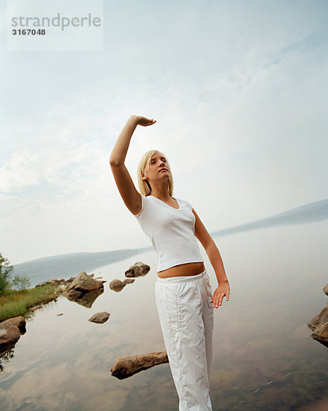 Junge Frau üben Yoga an einem See  Schweden.