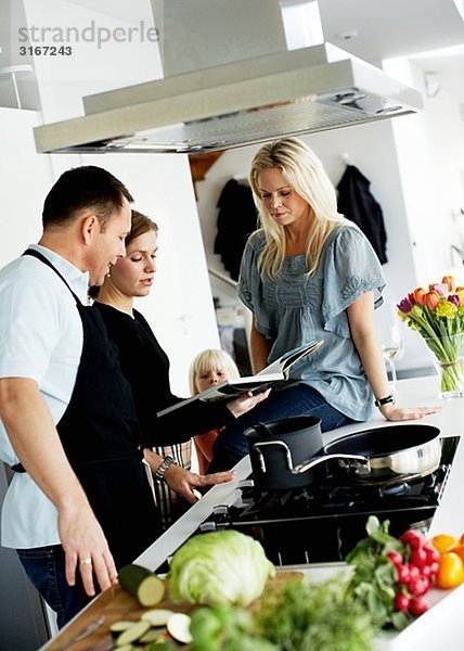 Ein Mann und zwei Frauen machen Abendessen zusammen Schweden.