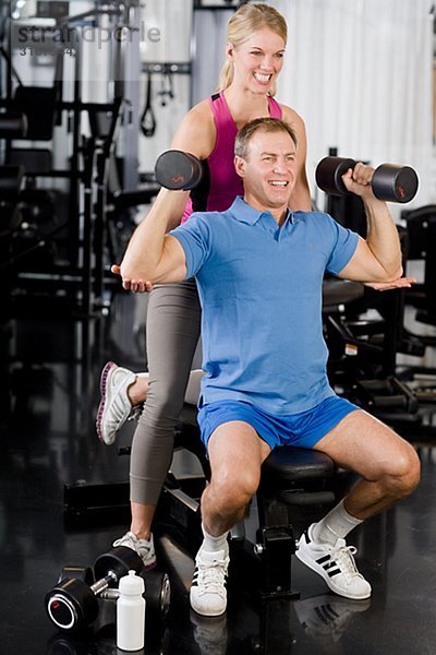 Ein Mann und eine Frau Krafttraining in einem Fitnessstudio Schweden.