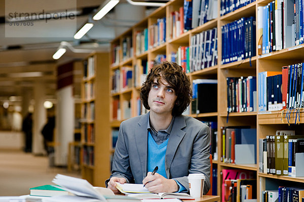 Eine männliche Studenten in einer Bibliothek Schweden.