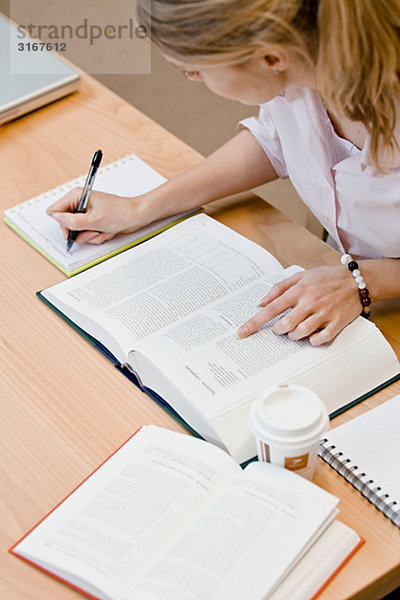 Ein weiblicher Student Studium in einer Bibliothek Schweden.