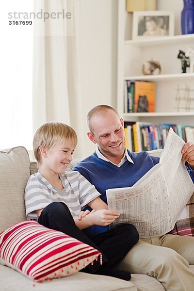 Vater und Sohn Lesen der Zeitung  Schweden.