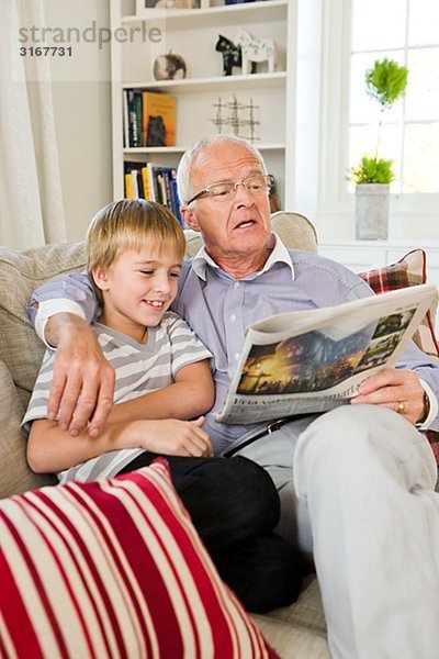 Großvater und Enkel in einem Sofa  lesen  Schweden.