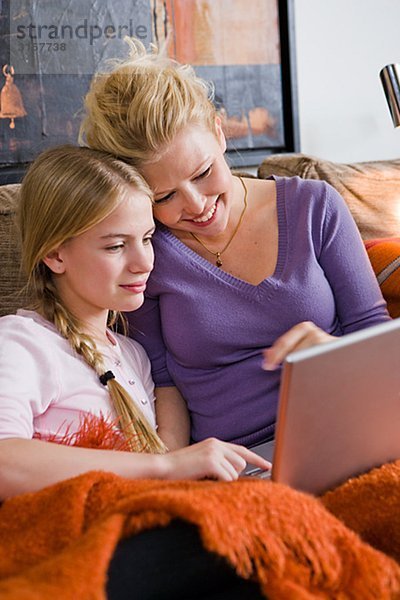 Mutter und Tochter mit einem Laptop in eine Couch  Schweden.