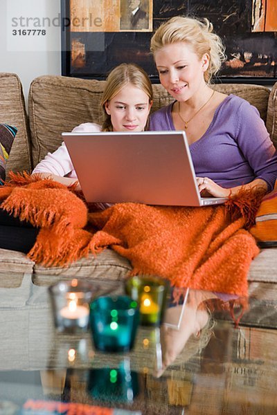 Mutter und Tochter mit einem Laptop in eine Couch  Schweden.