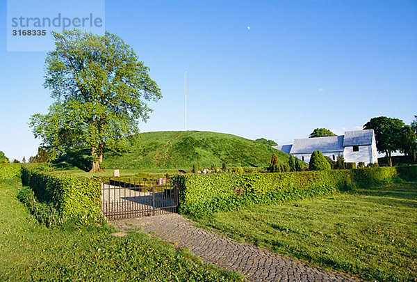 Eine Kirche und eine Tumulus Jelling Jütland Dänemark.