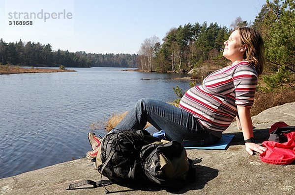 Eine schwangere Frau ein See Schwedens.