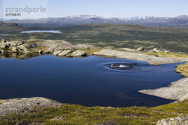 Menschen Schwimmen in einem kleinen See in den Bergen  Schweden.