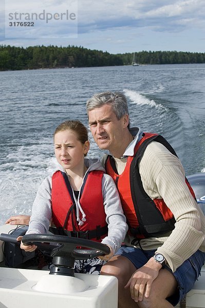 Ein Mann einer Mädchen beizubringen  wie man fahren ein Boot  Stockholmer Schären  Schweden.