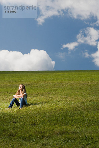 Mädchen auf einem Feld sitzend