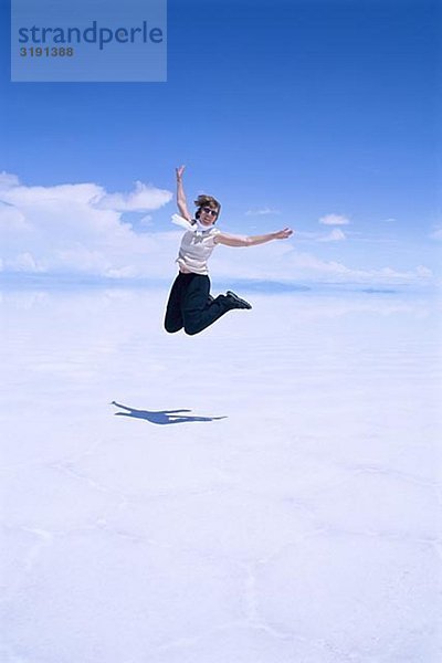 Eine Frau in einer Salztonebene springen.