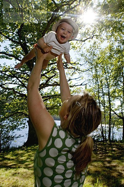 Mutter anheben ein Baby in der Luft  Schweden.