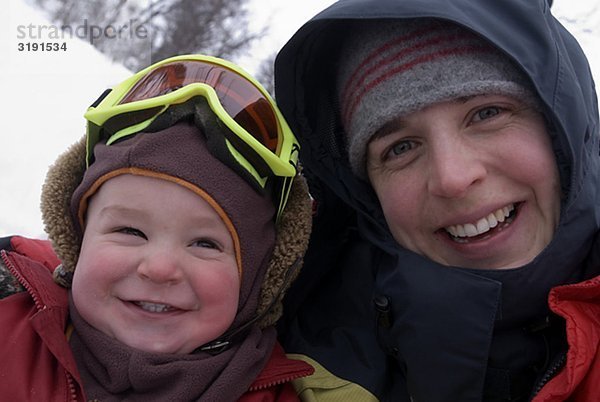 Eine lächelnd Mutter mit Kind Winter am Tag  Schweden.