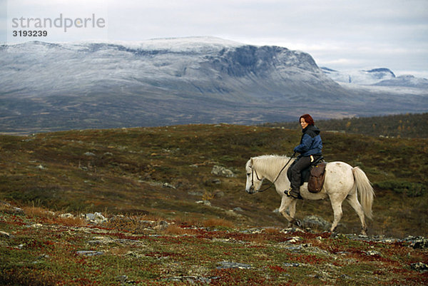 Sami Frau Fahrer auf einem Pferd in der Natur  Schweden.