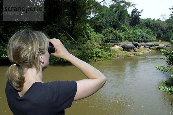 Ein Frau blickt auf Nilpferd  Uganda.