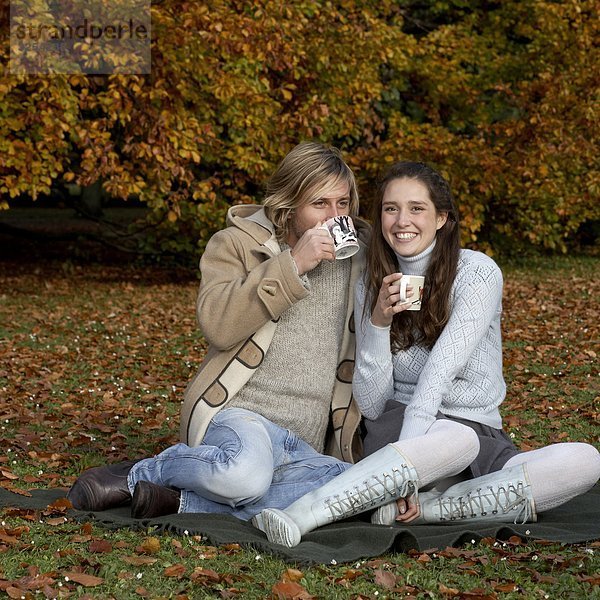 Ein paar mit eine Tasse Kaffee in einem Park  Skane  Schweden.