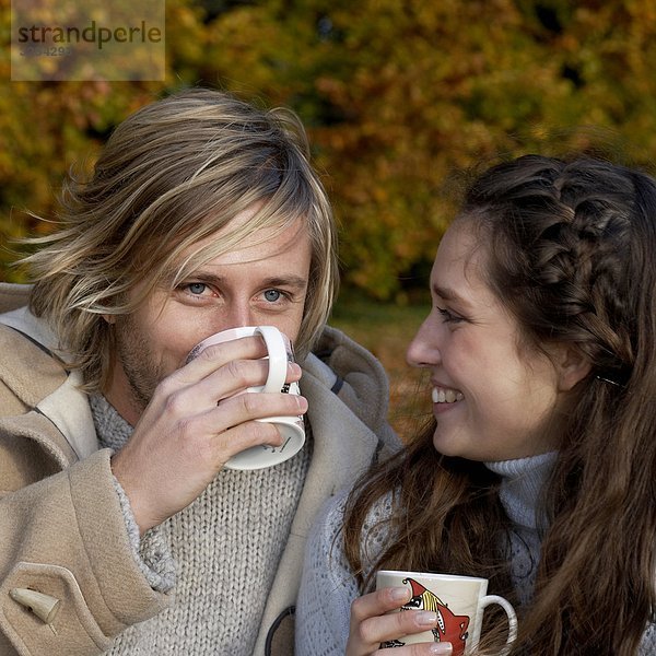 Ein paar mit eine Tasse Kaffee in einem Park  Skane  Schweden.