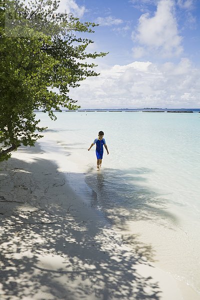 Junge zu Fuß an einem Strand  den Malediven.