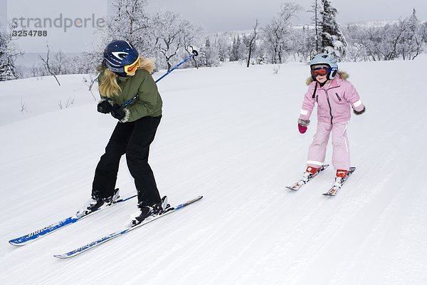 Zwei Schwestern tun Slalom-Skifahren  Schweden.