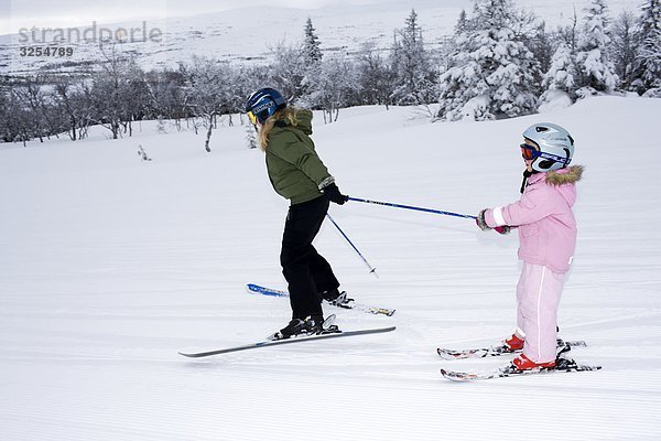 Zwei Schwestern tun Slalom-Skifahren  Schweden.