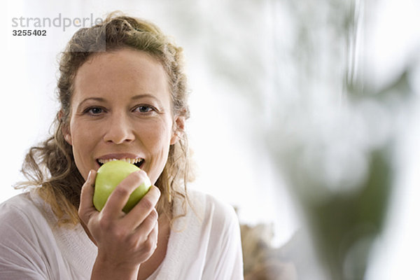 Frau mittleren Alters beim Essen eines Apfels