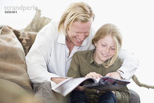 Vater und Tochter beim Lesen einer Zeitschrift