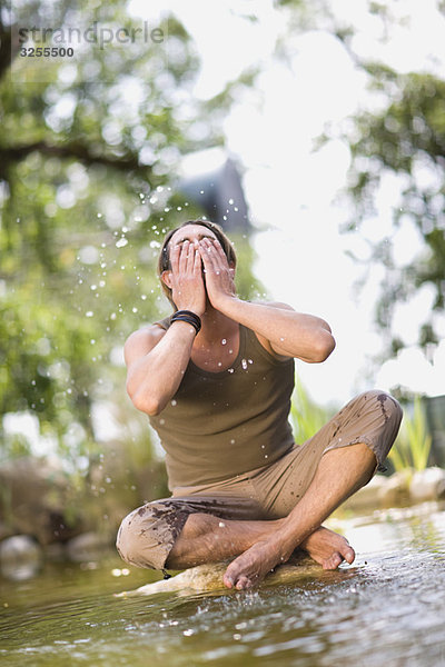 Mann im Fluss sitzend