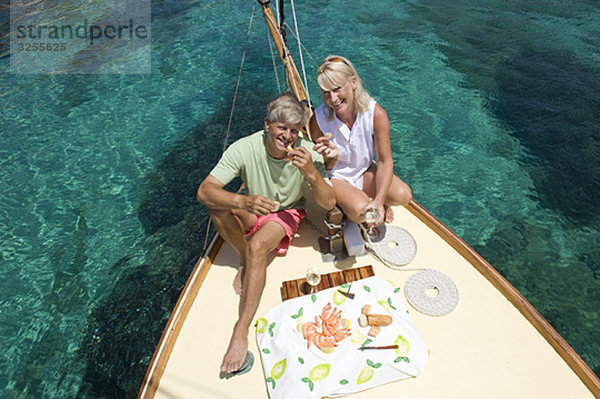 Ein Picknick für ältere Paare beim Segeln