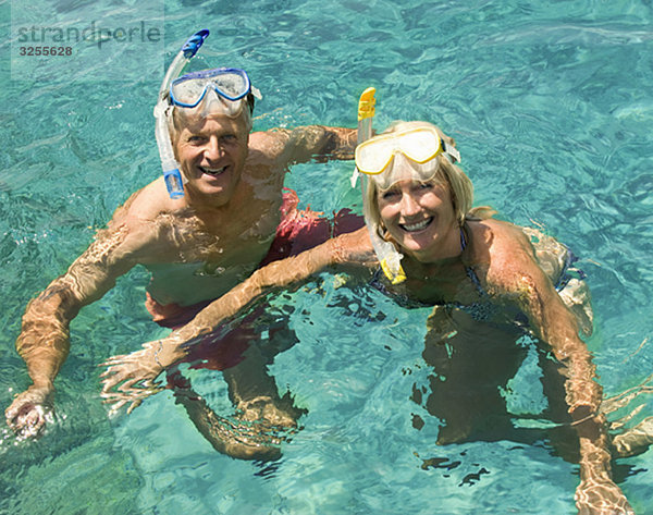 Ein älteres Paar schwimmt mit Schnorcheln