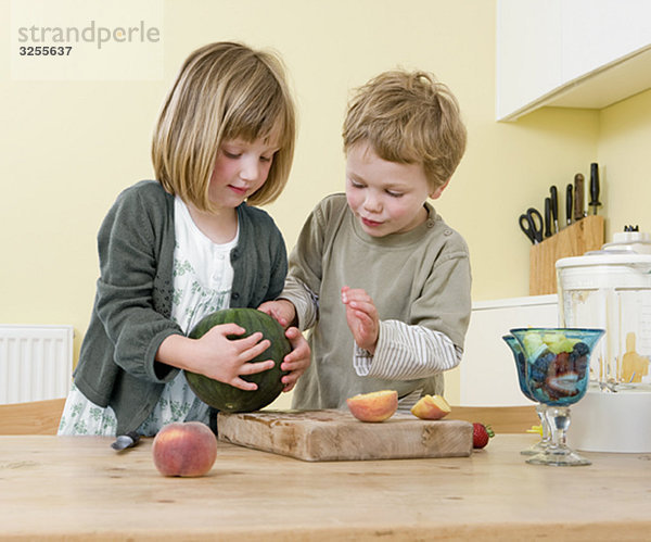 Junge und Mädchen beim Zubereiten von Obst