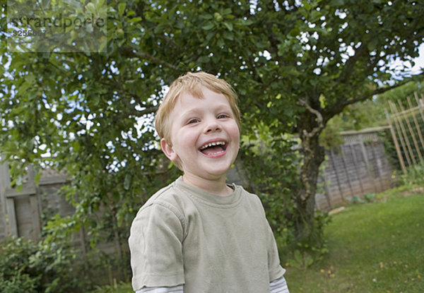 Junge lacht im Garten