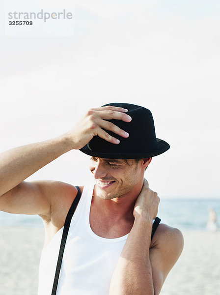 Mann mit Hut am Strand