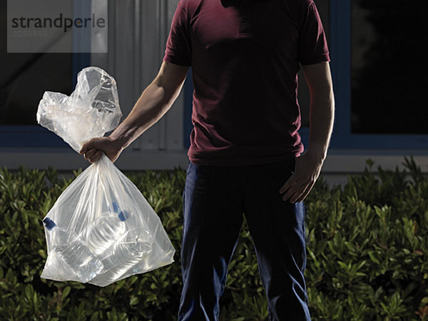 man carrying bag of water bottles